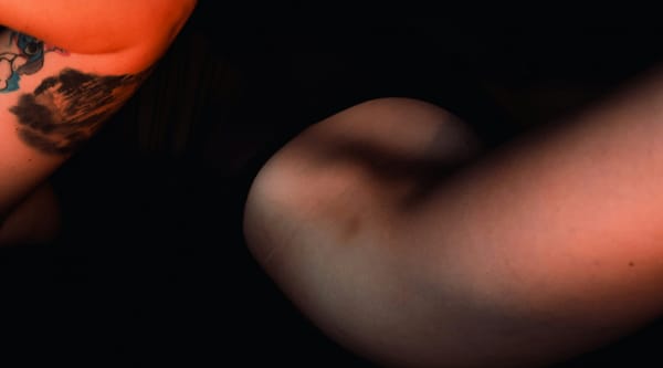 A close up of someone's arm and leg, partly in shadow